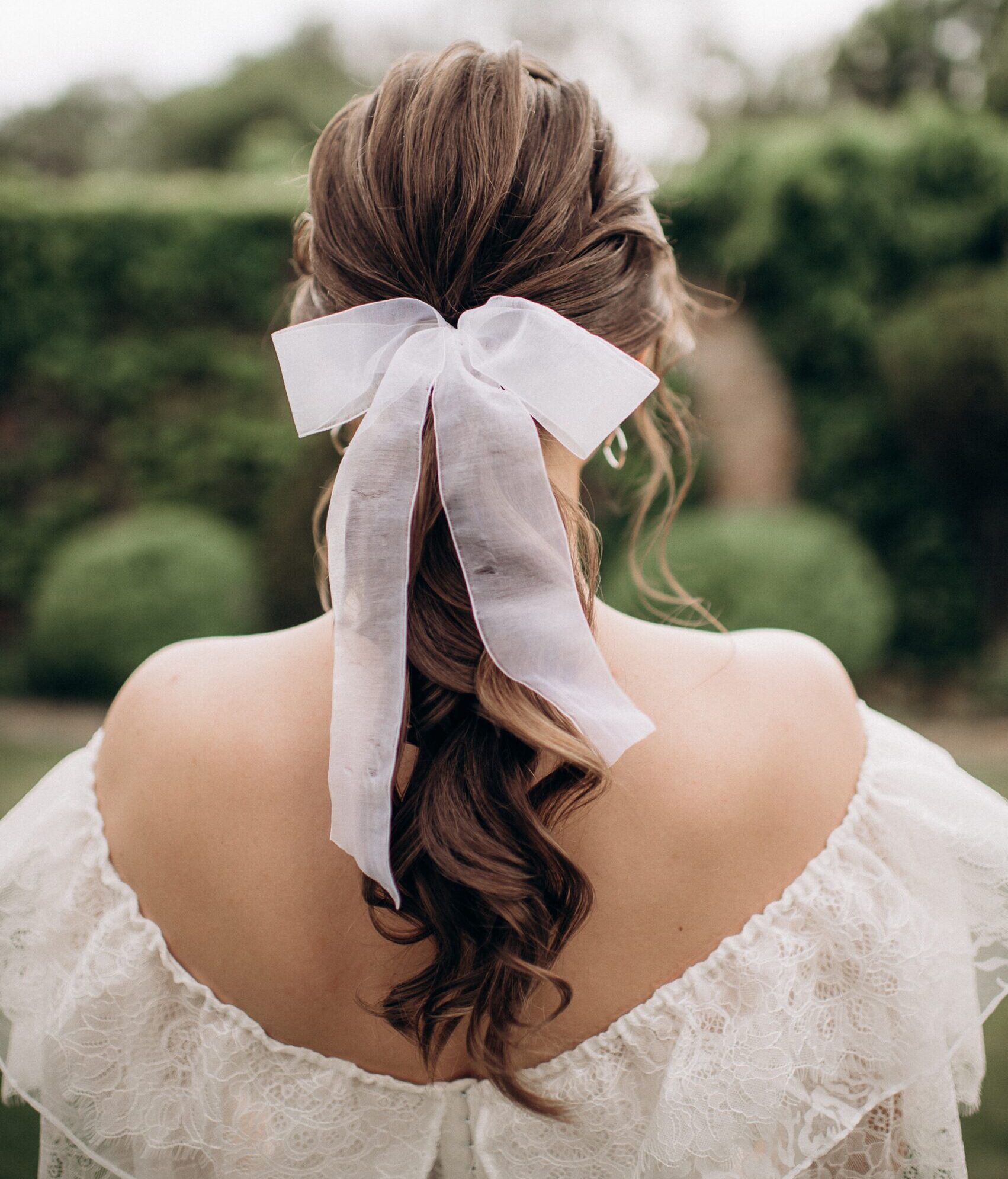 Bride with curled ponytail and a bow