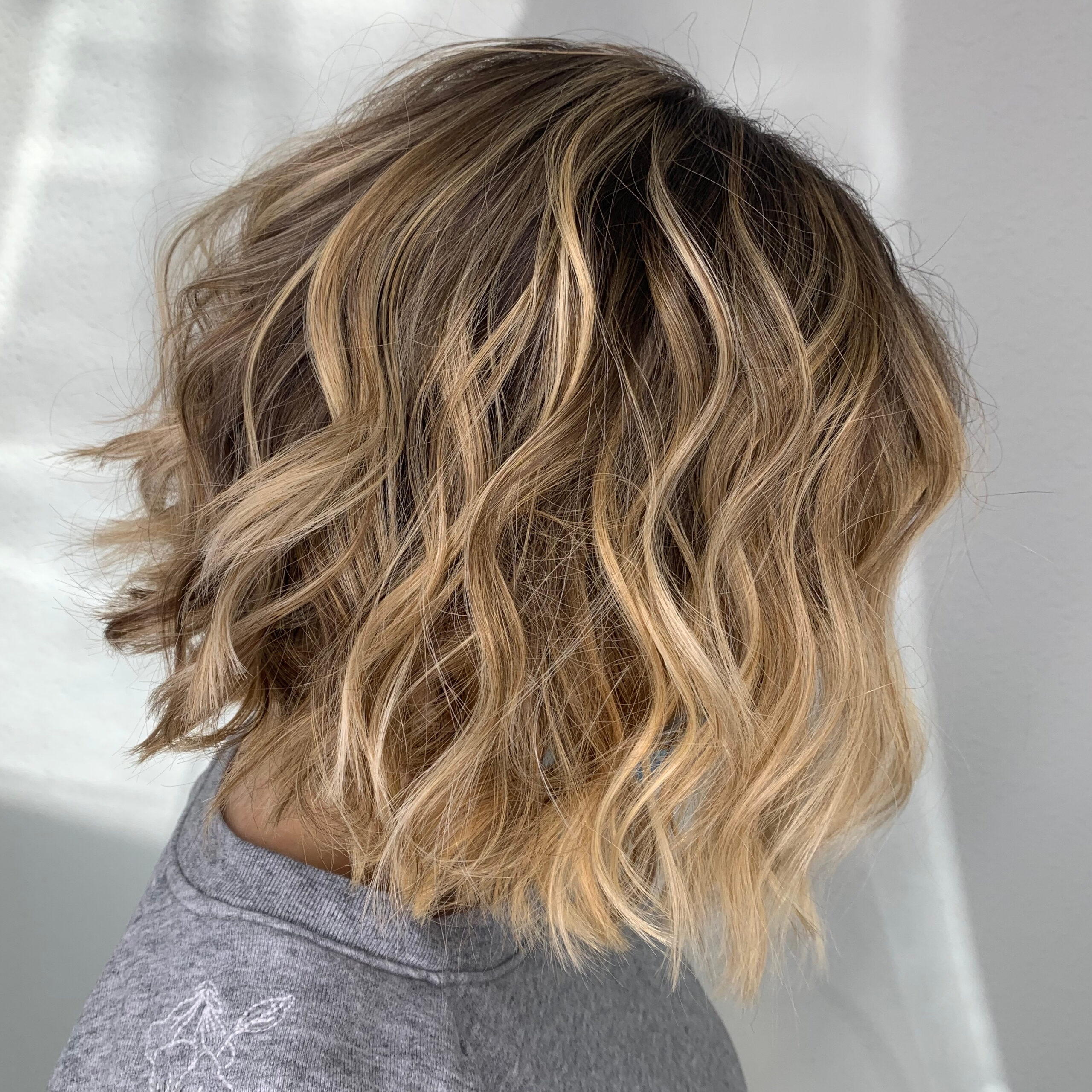 Woman with wavy bob haircut and blonde highlights