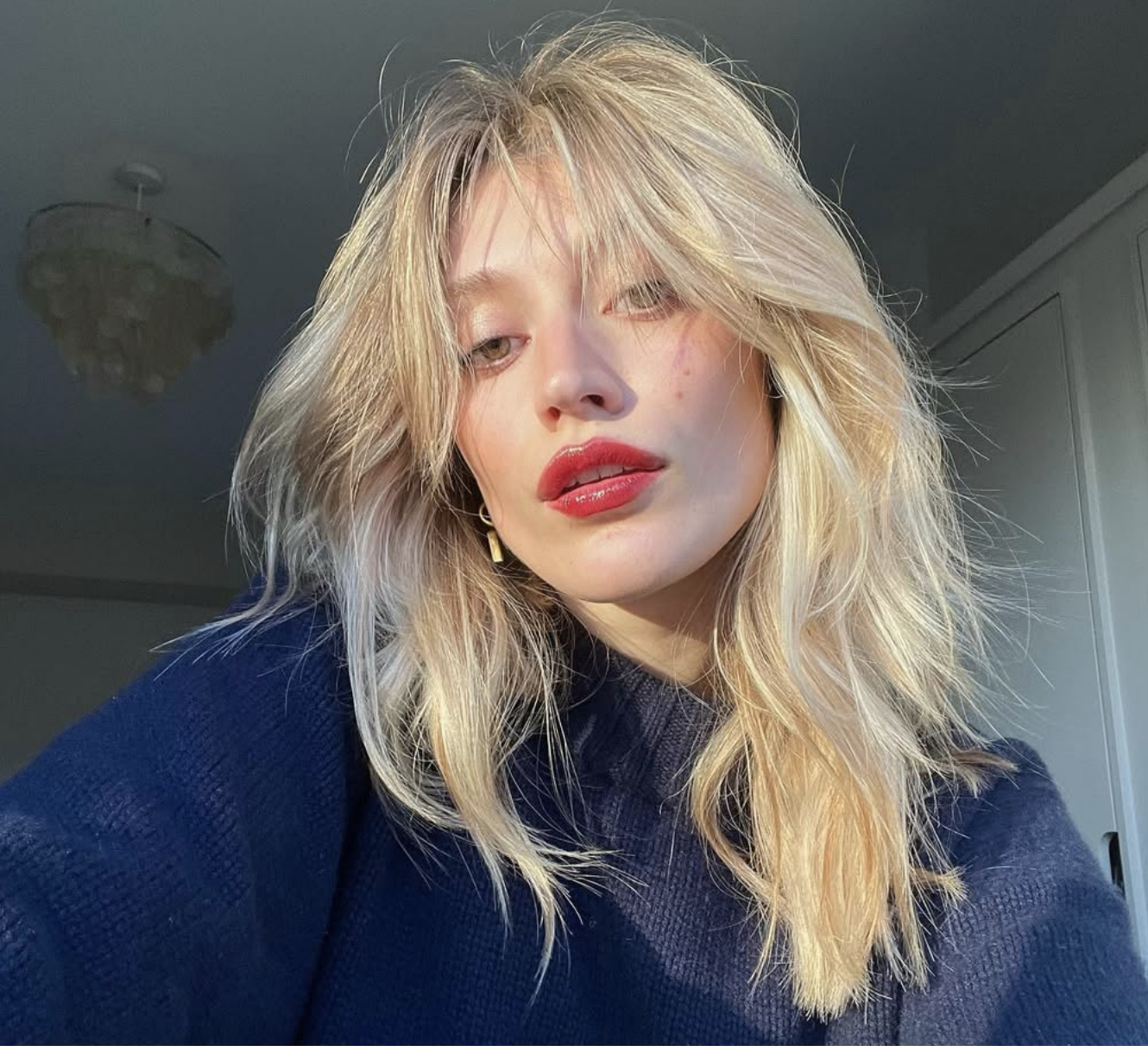 Blonde woman with curtain bangs and shaggy layers