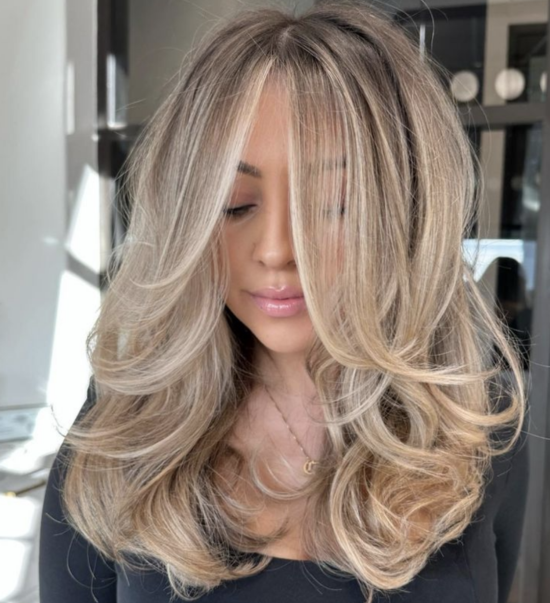 Photo is an example of a woman with blonde feathery layers